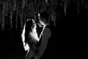 bride and groom by weeping willow at night