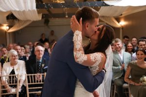 bride and groom share first kiss