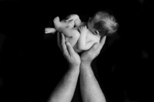 new born baby in dads hands