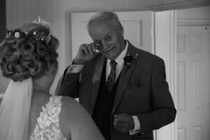 father wipes a tear with his daughter bride