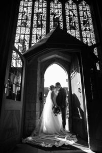 bride and groom silhouetted in church doorway