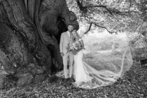 bride and groom by yew tree in doddington hall