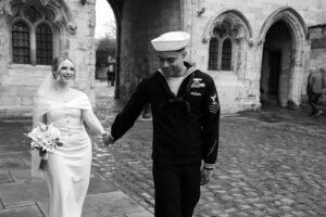 black and white image of bride and groom walking through Bailgate area of Lincoln