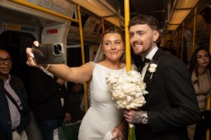 bride and groom take selfie on tube train